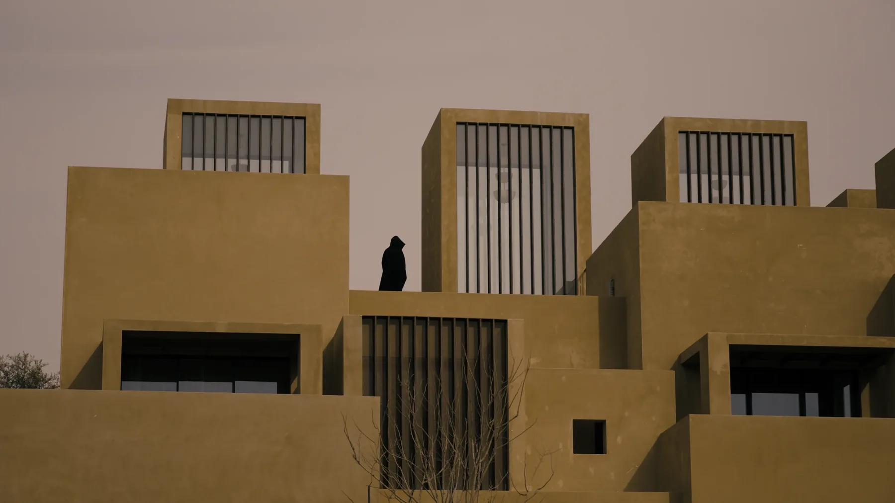 Detail of the stacked massing, a figure standing within one of the openings