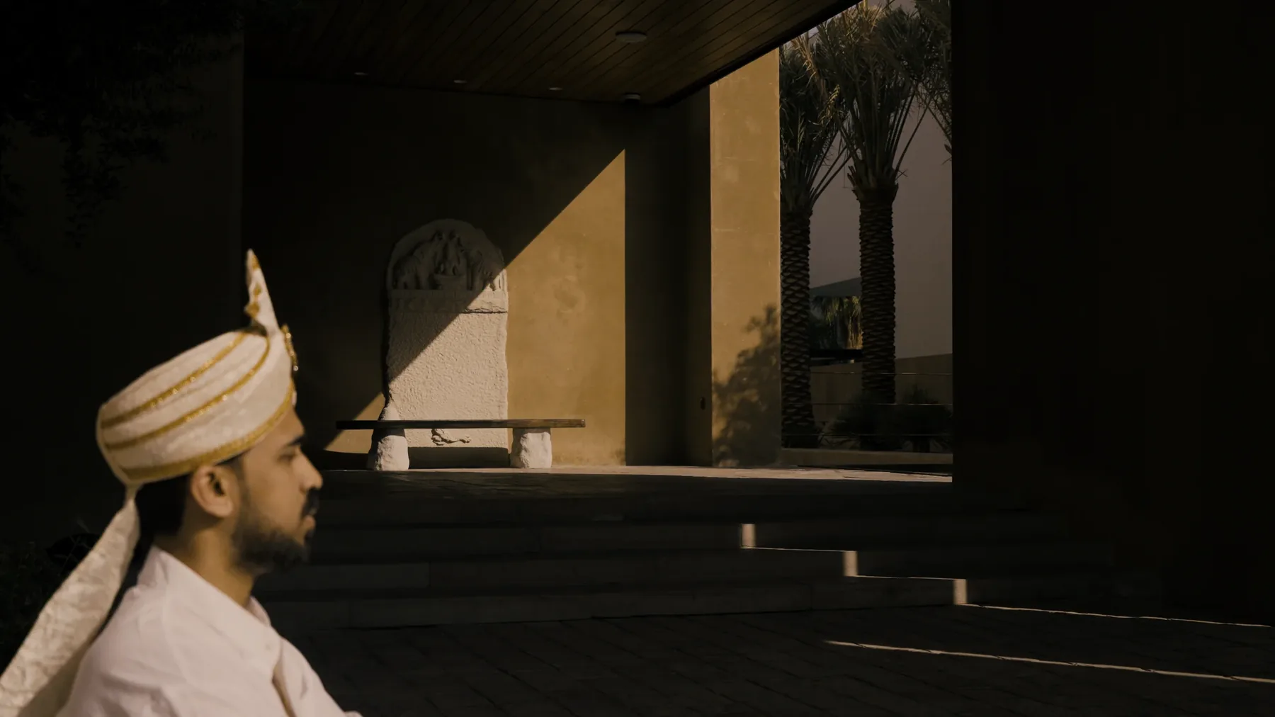 Portrait of a figure in a turban within the shadowed colonnade