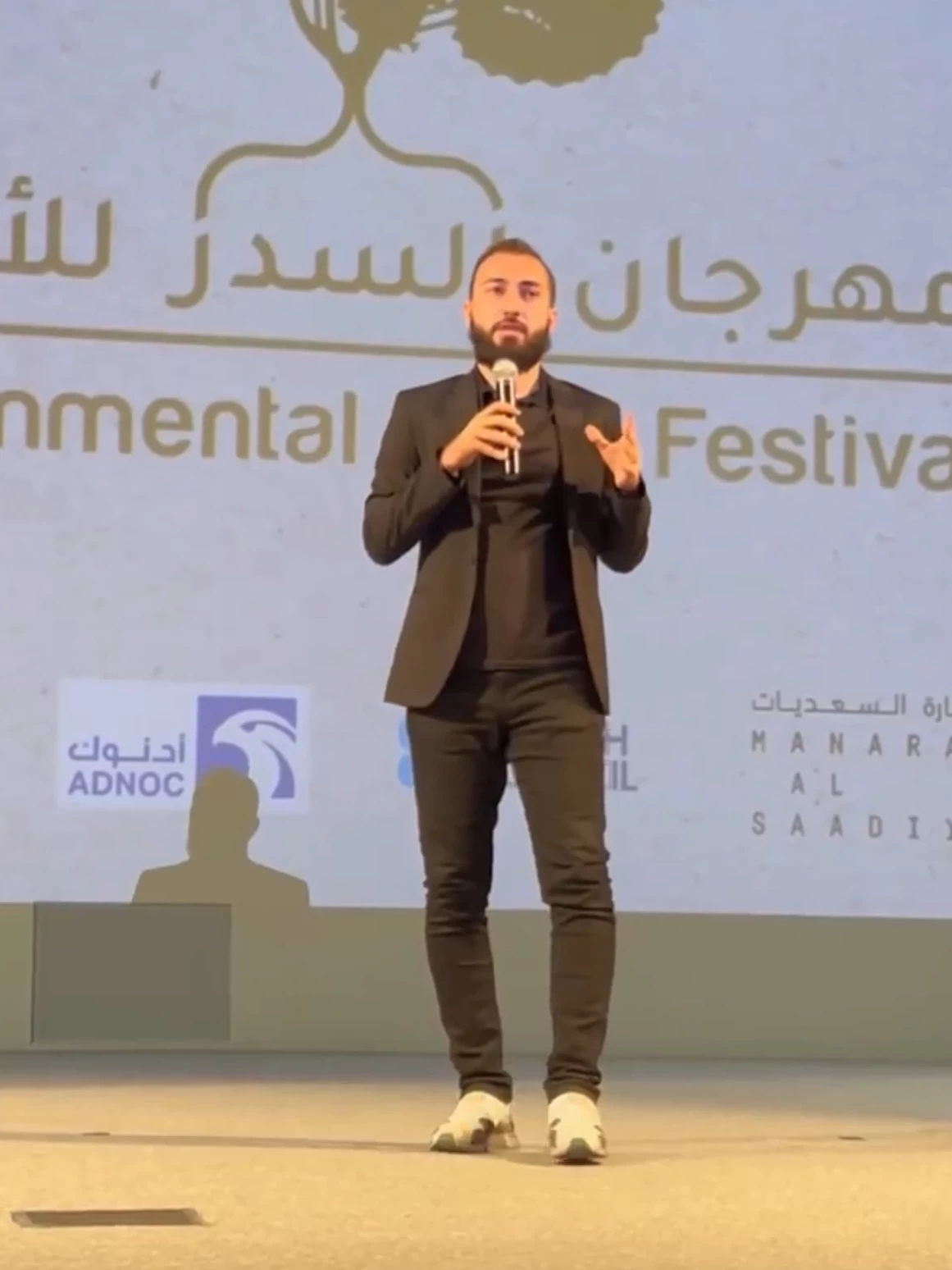 Shoayb presenting the documentary UMAH on stage at Al Sidr Environmental Film Festival